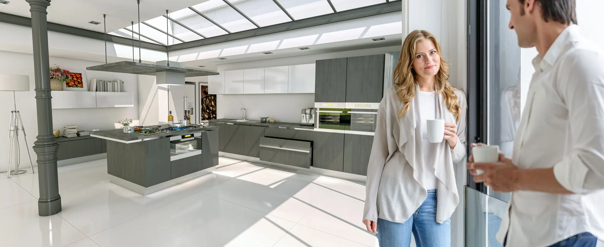 Couple by window in modern kitchen with skylight.