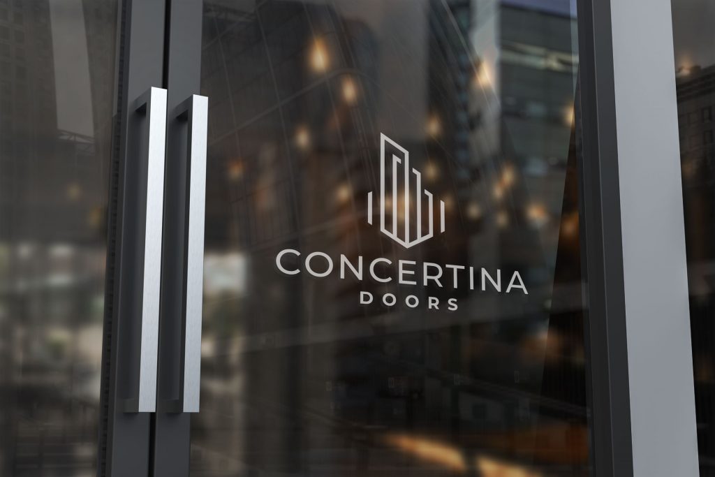 Close-up of a glass door with silver handles, featuring the white logo and text "CONCERTINA DOORS" overlaid on the glass.